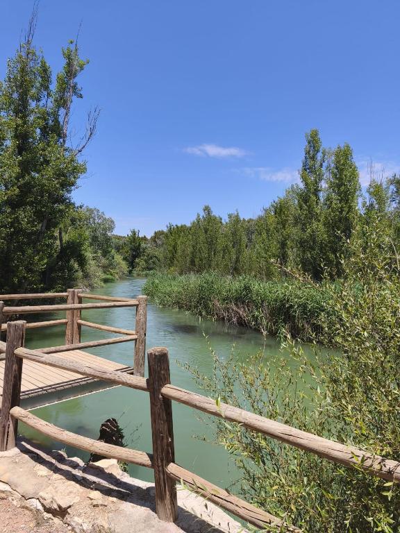 a bridge over a river next to a fence at Casa Dulcinea in Alborea
