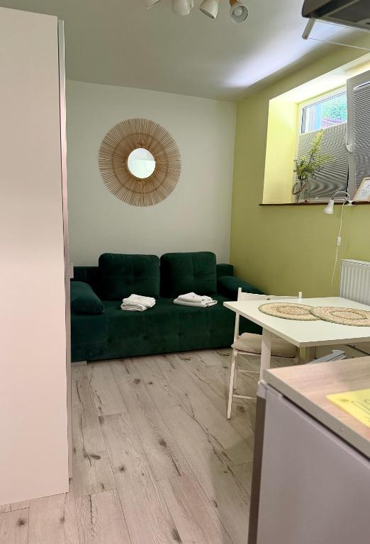 a living room with a green couch and a table at Apartament Zielony Gaj Ustroń Wczasowa 90 in Ustroń