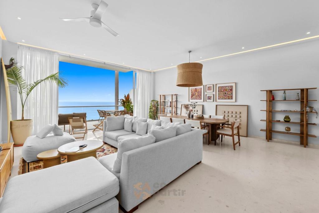 a living room with a couch and a table at Beachfront Modern Sanctuary - Bolongo in Higuera Blanca