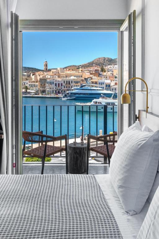 a bedroom with a bed and a view of the water at Eclectic Syros in Ermoupoli