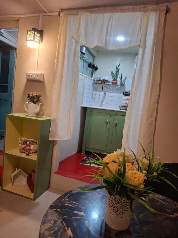 a kitchen with a table with flowers on it at GD's Homestay in Shillong