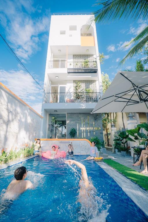 a group of children playing in a swimming pool at May Bliss Villa in Danang