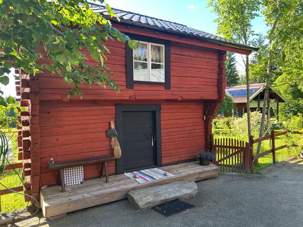a red cabin with a door and a porch at Härbre Cabin in Årjäng