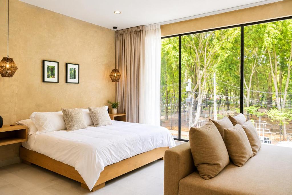 a bedroom with a bed and a large window at Sweven Hotel Boutique in Guadalajara