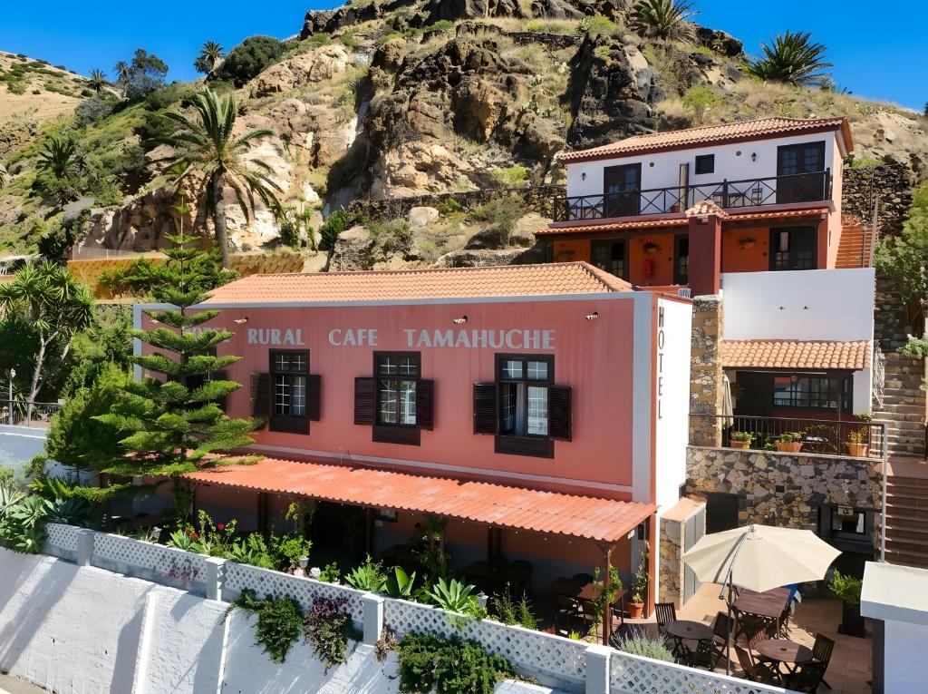 a building in front of a mountain at Tamahuche Hotel Rural in Vallehermoso