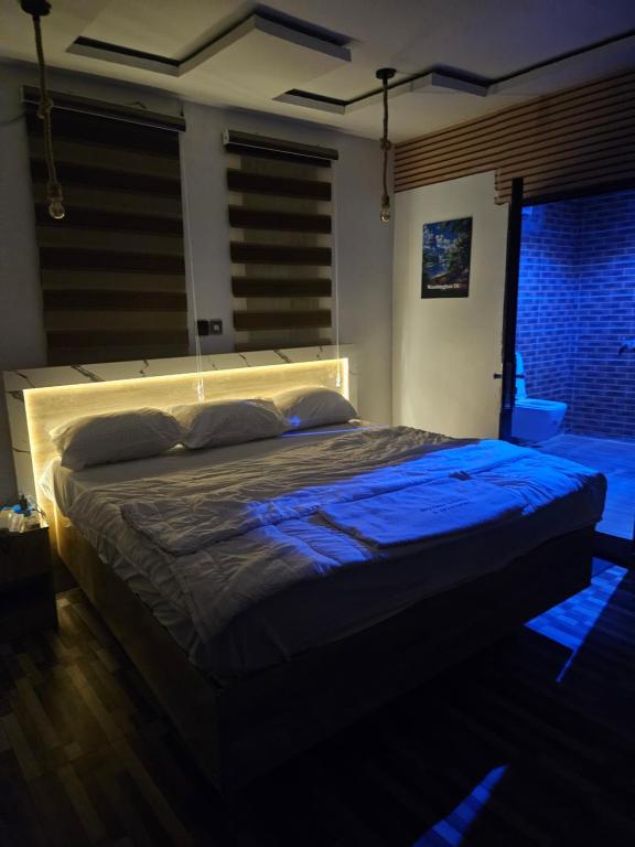 a bedroom with a large bed in a dark room at The Royam Hotel and Apartments in Ibadan