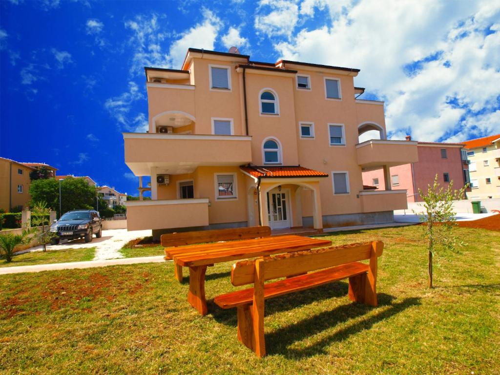 a wooden bench in front of a house at Apartments Medulin 396 in Medulin