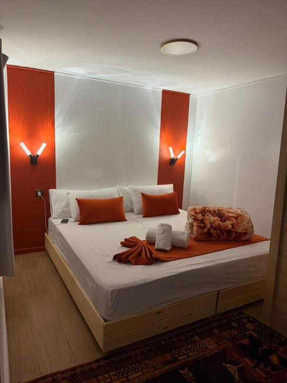 a bedroom with a large white bed with orange accents at Auberge de Chez Momo in Asilah