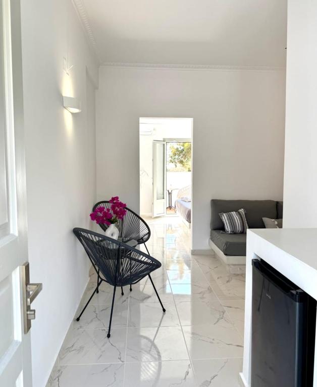 a living room with a black chair and a fireplace at V Angelo Prestige Rooms- Adults Only in Perissa