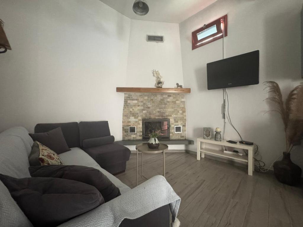 a living room with a couch and a fireplace at Moraitis Studios in Skiros