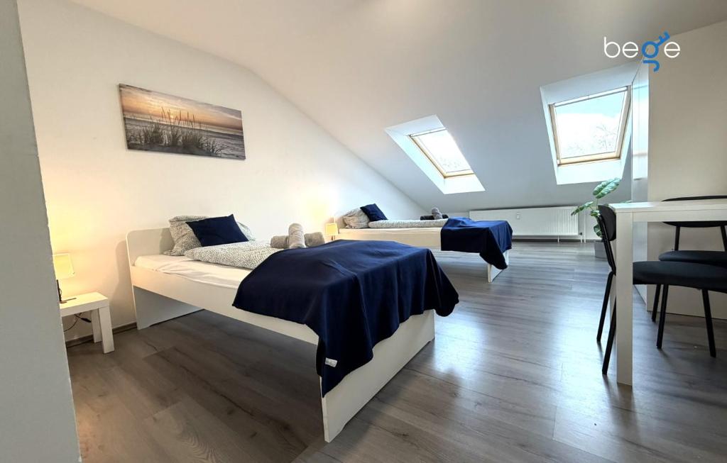 a attic bedroom with two beds and a desk at BEGE APARTMENTS WorkSpace in Marl