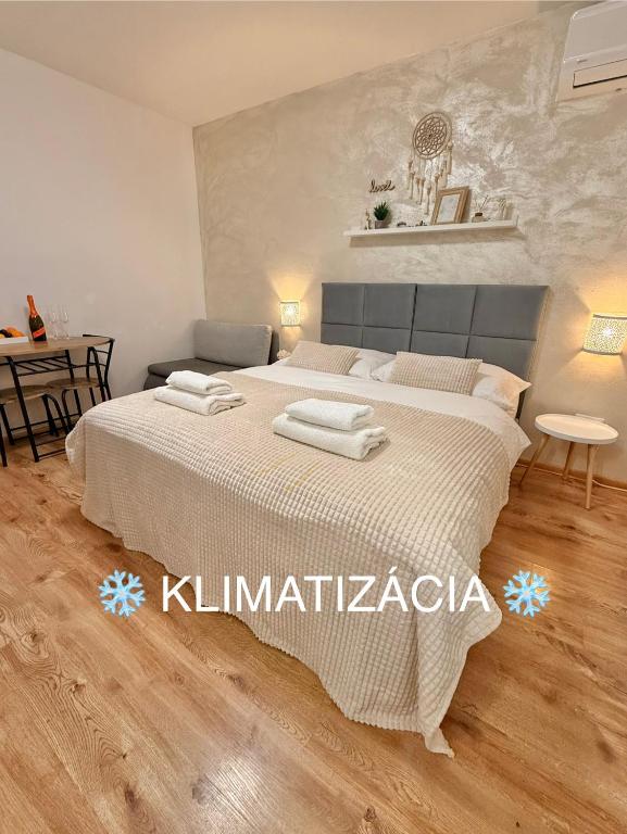 a bedroom with a large bed and a table at Apartmány ZELENÝ DOM in Podhájska