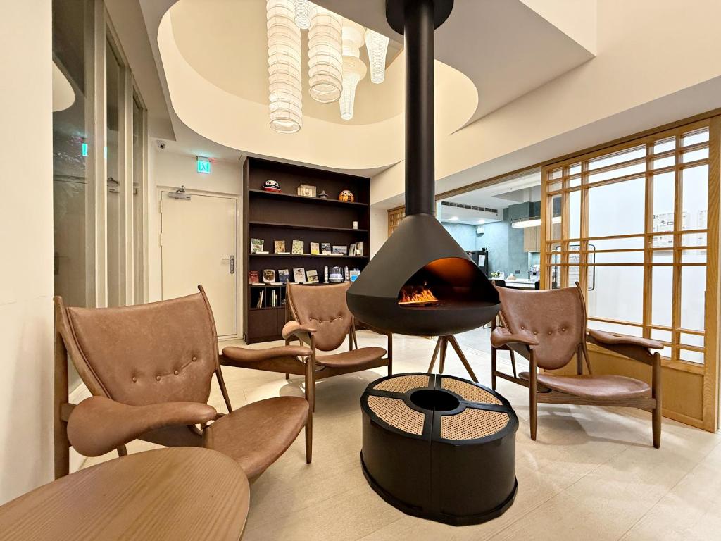a living room with a fireplace and chairs at A Day A Room in Taichung
