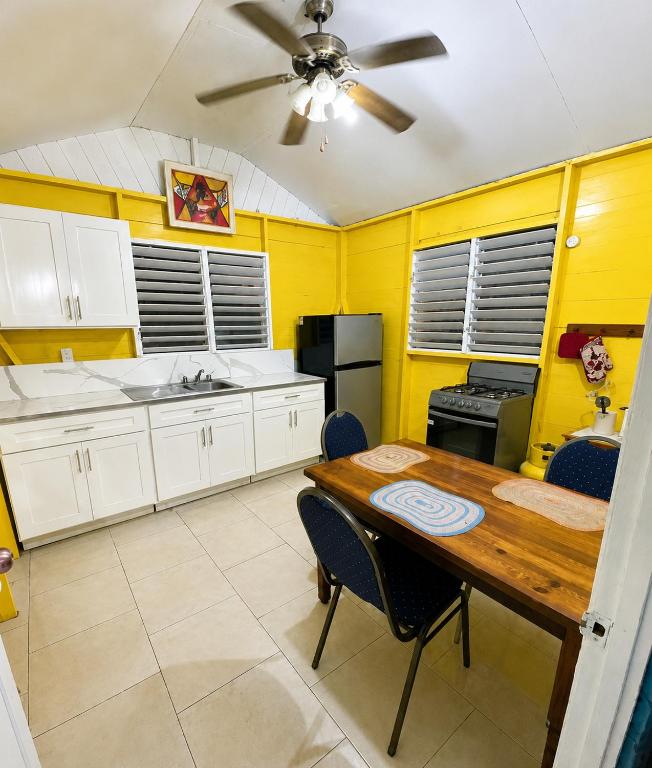 a kitchen with a table and a ceiling fan at Rooms on the 7 Mile in Negril
