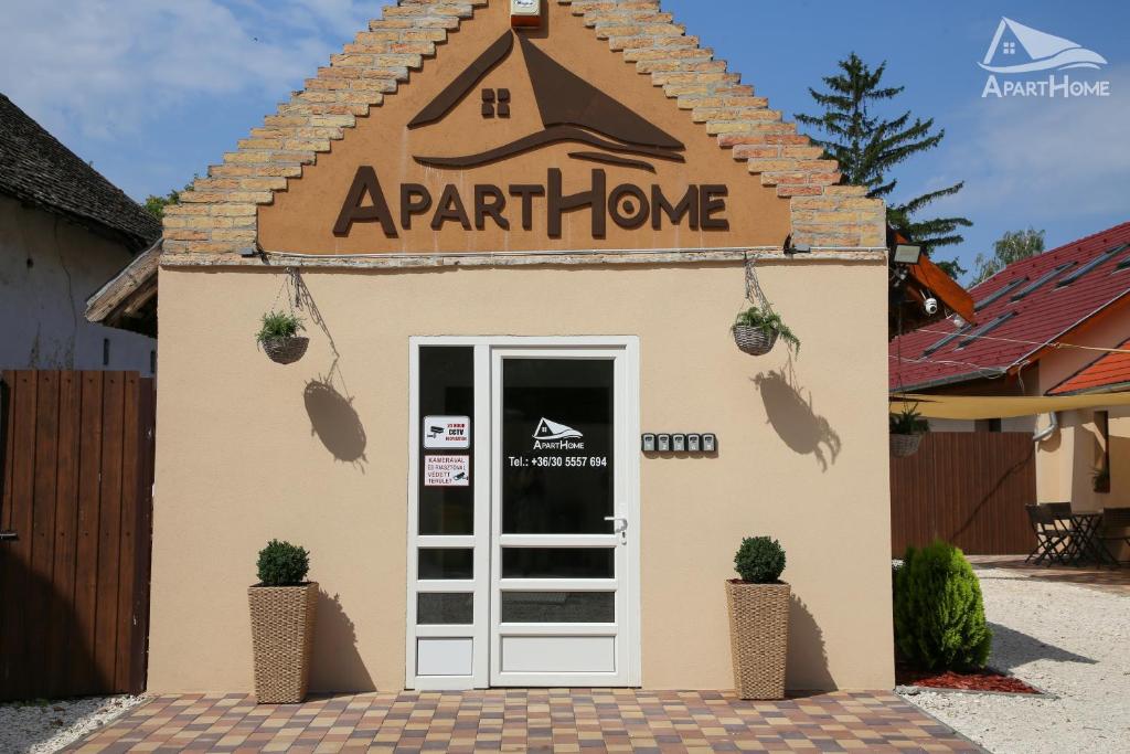 a small building with a door and a sign on it at ApartHome in Makó