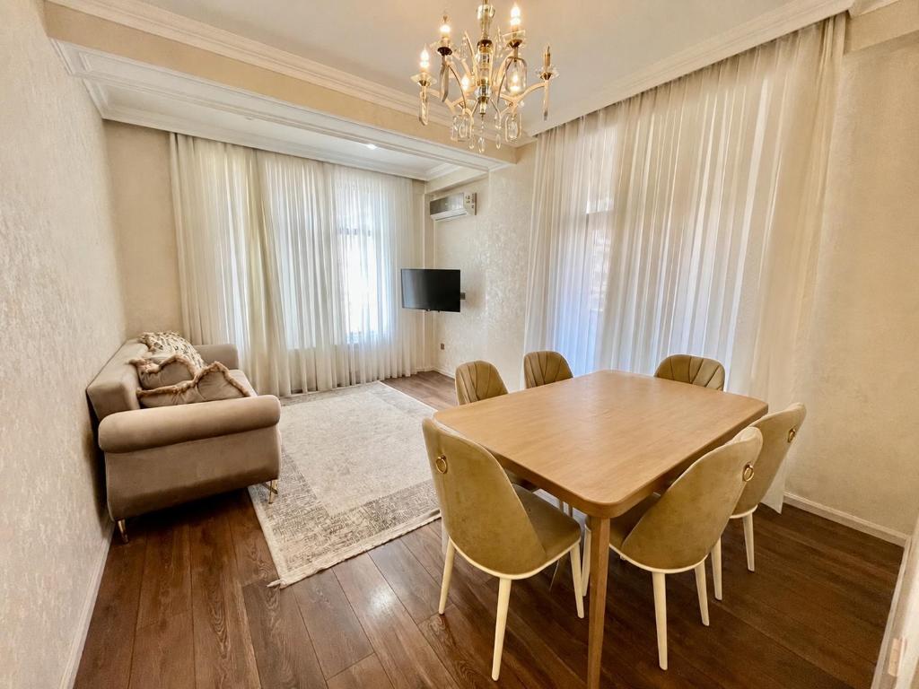 a dining room with a table and a couch at Light & Comfortе in Mekhrably