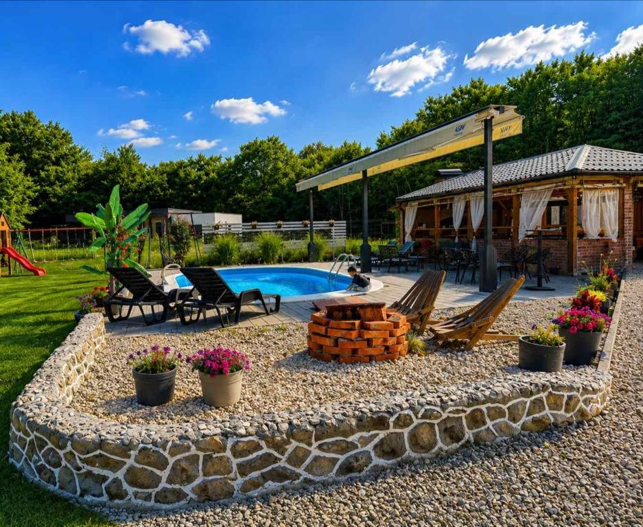 a backyard with a pool and chairs and a house at Jerry's Forest in Banja Luka