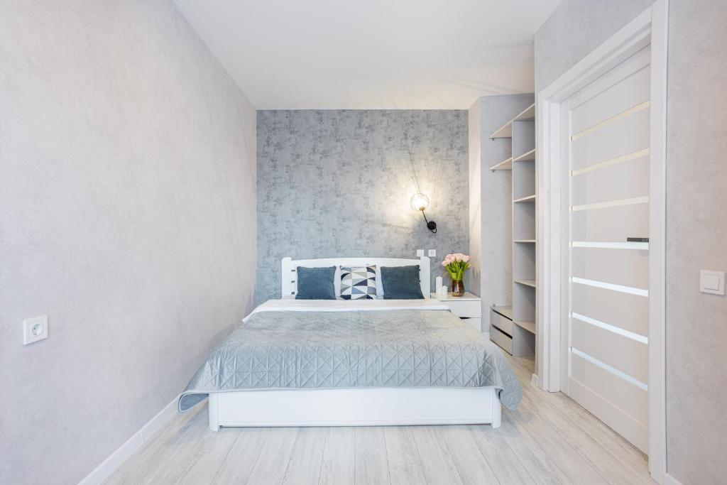 a bedroom with a white bed and a book shelf at Fayna Town Comfort #173 in Kyiv
