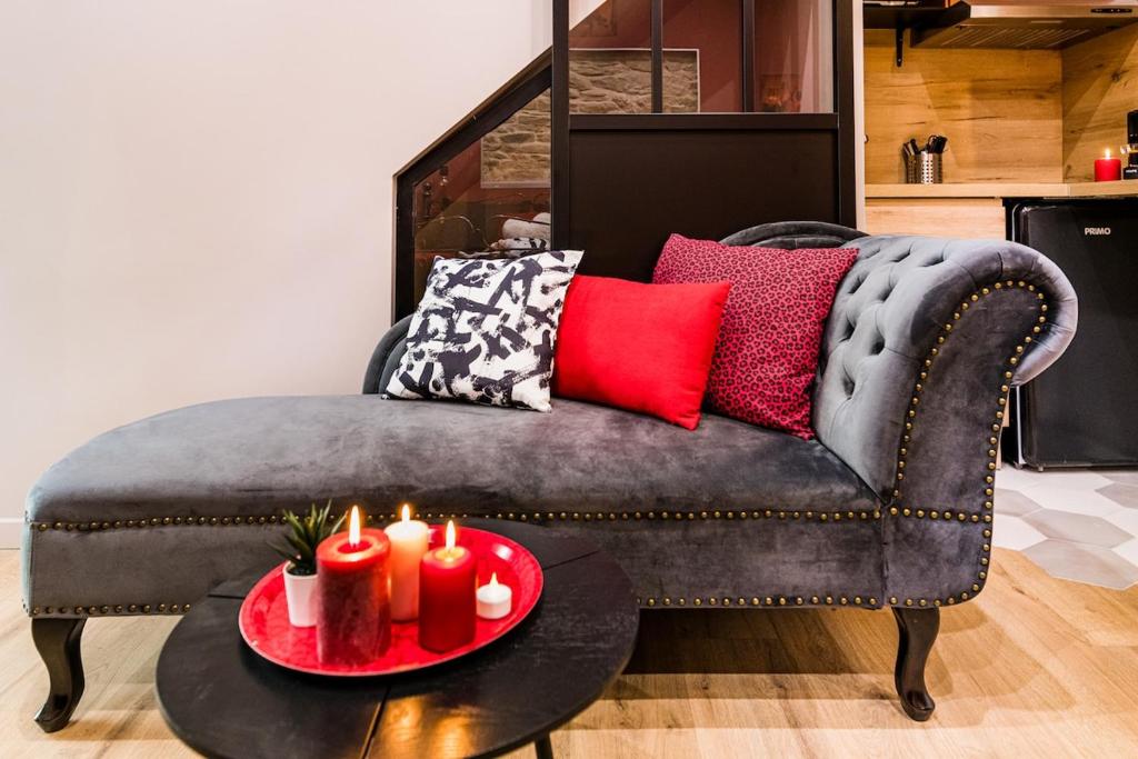 a living room with a couch with candles on a table at Cachette Secrète in Bourgoin