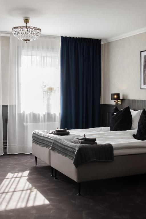 a bedroom with a large bed with a blue curtain at Central Hotellet Tierp in Tierp
