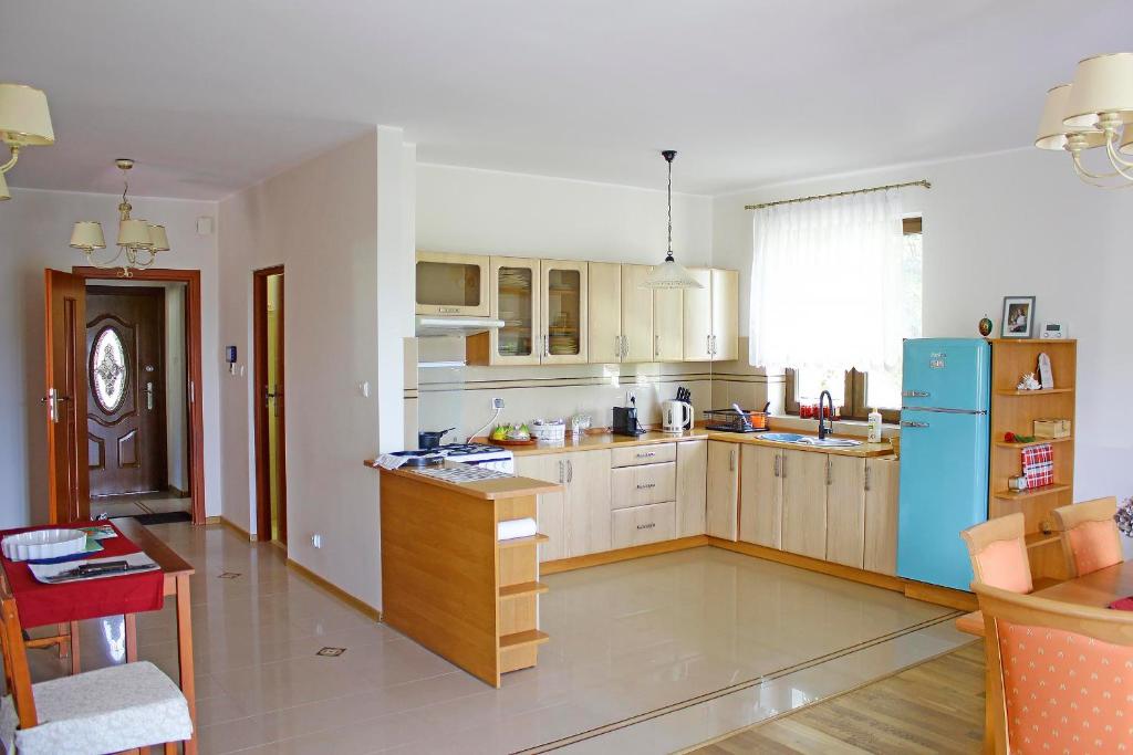 a kitchen with a blue refrigerator and wooden cabinets at Dom na Wynajem Gdynia Grabówek in Gdynia