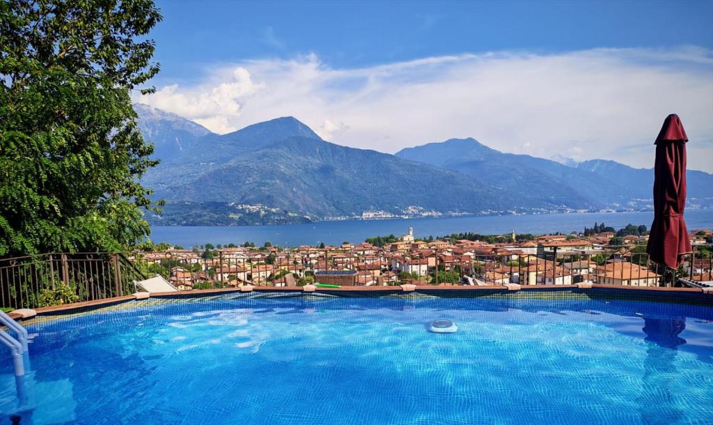 a large swimming pool with a view of a city at Ulivi on the lake in Dongo