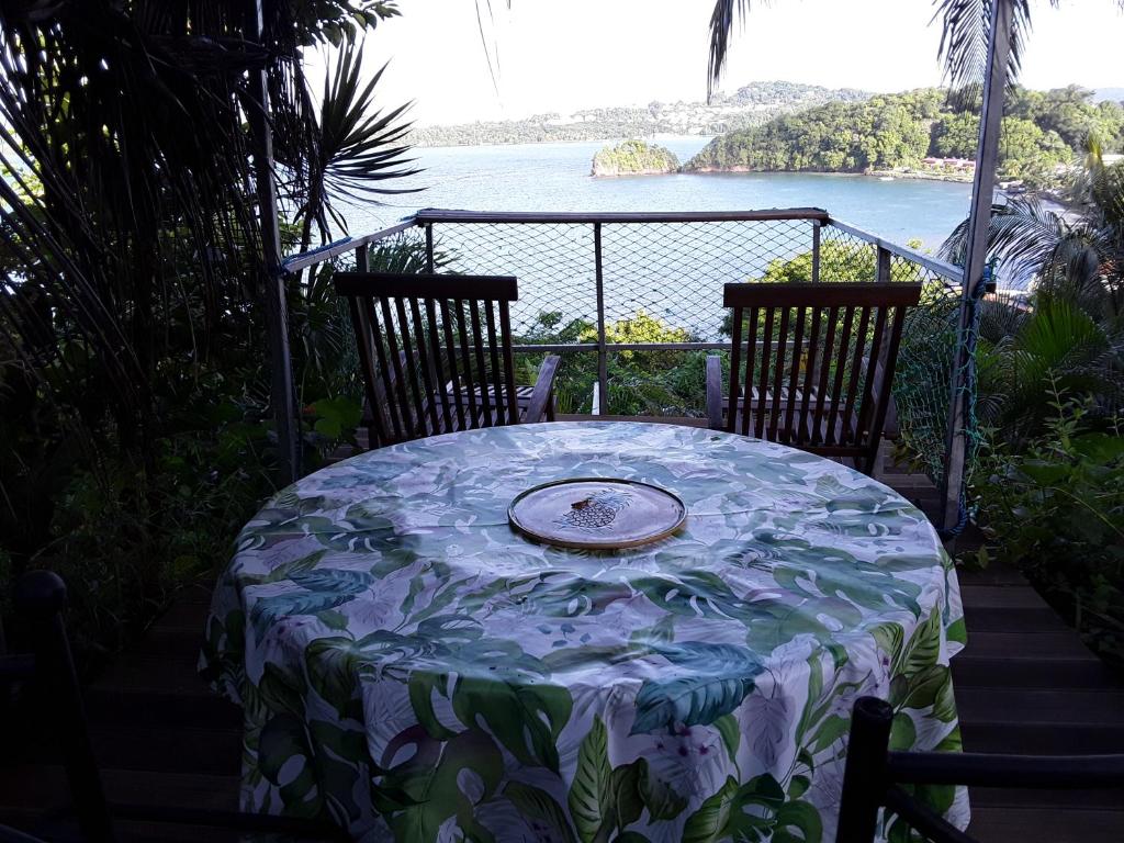 a table with a plate on it on a balcony at La Case du Pêcheur in La Trinité
