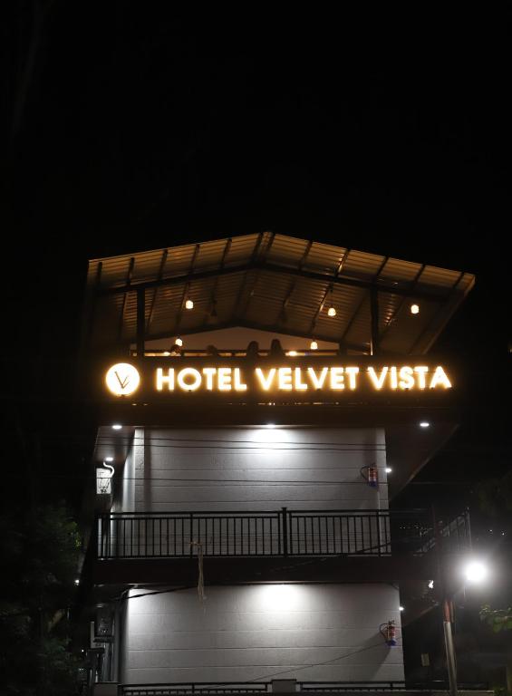 a hotel sign on top of a building at night at Hotel Velvet Vista in Rishīkesh