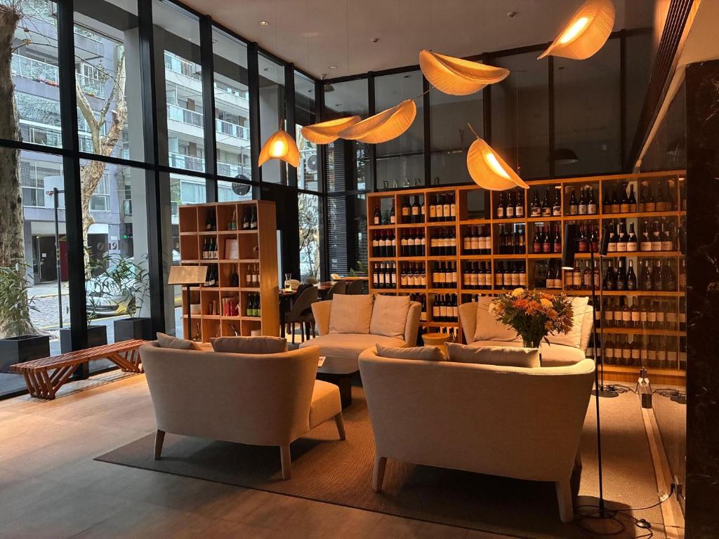 a library with couches and chairs and bookshelves at Pleno Palermo Soho in Buenos Aires