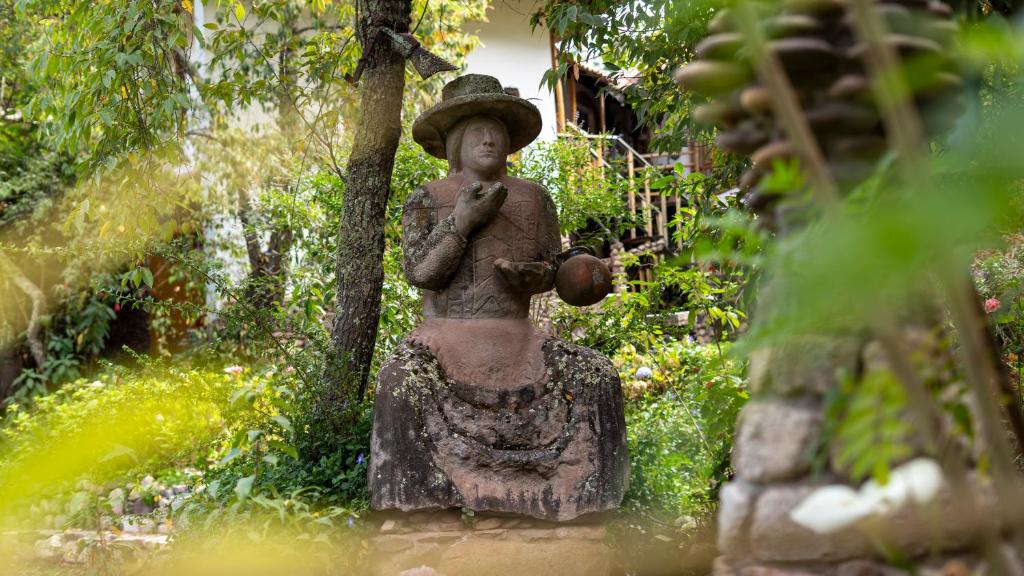 a statue of a woman standing next to a tree at Casa de campo Yoga Retreat in Urubamba