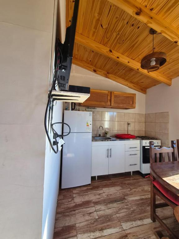 a kitchen with a white refrigerator and a table at Cabaña de Mia in Villa Traful