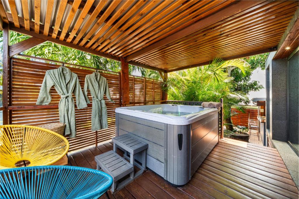 a hot tub on a deck with a table and chairs at Le Secret Tropical - Parenthèse jacuzzi in Sainte-Marie