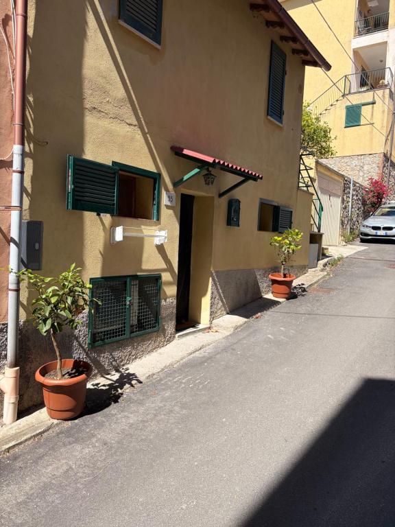 an empty street with potted plants on the side of a building at SnowWhite Home in Porto Ercole