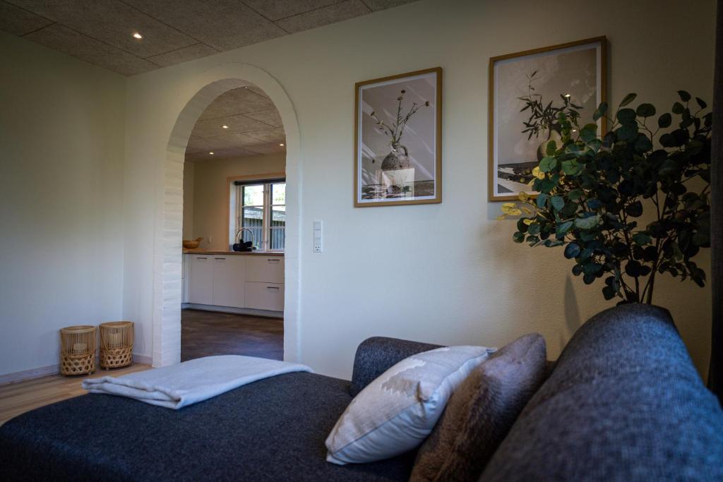 a living room with a couch and a plant at Billund Guest Lodge 2 in Hejnsvig