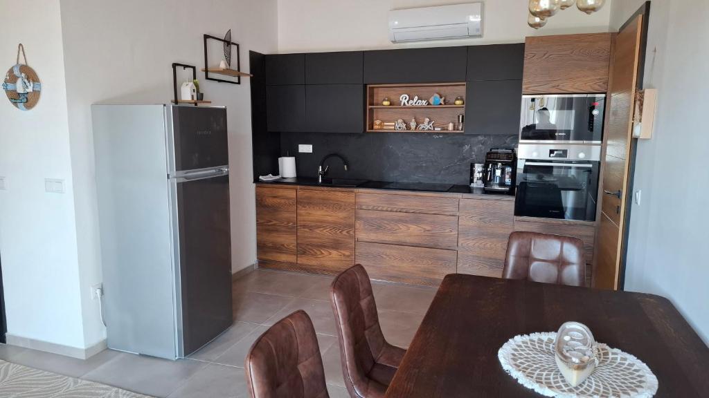 a kitchen with a wooden table and a refrigerator at Mirtusz Apartmanház in Balatongyörök