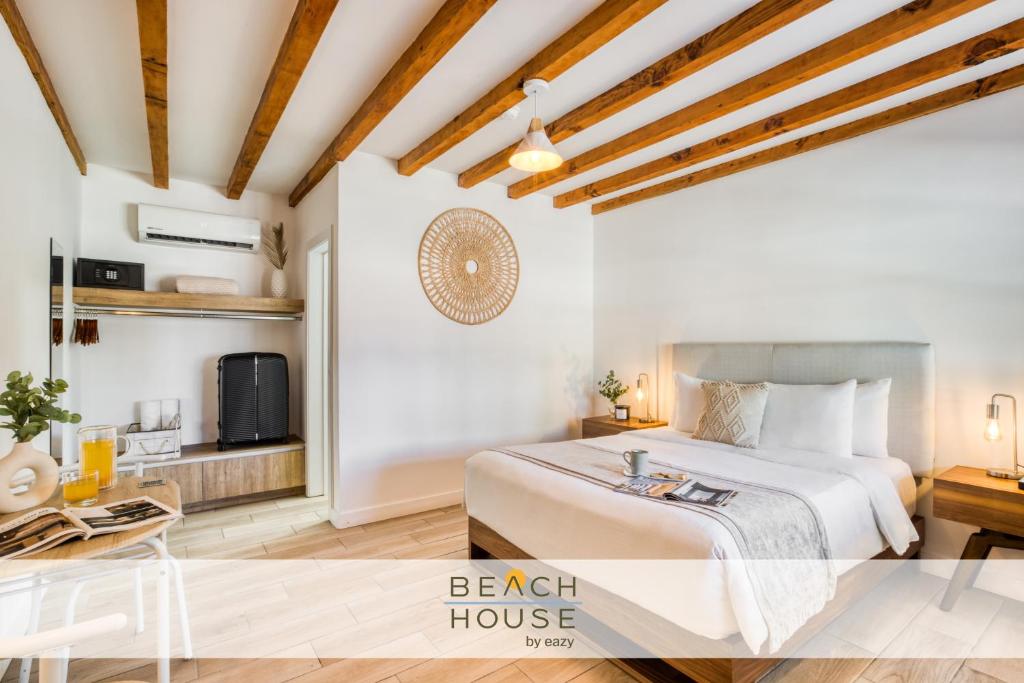 a bedroom with a bed and a table and a tv at Beach House by ULIV in Ensenada