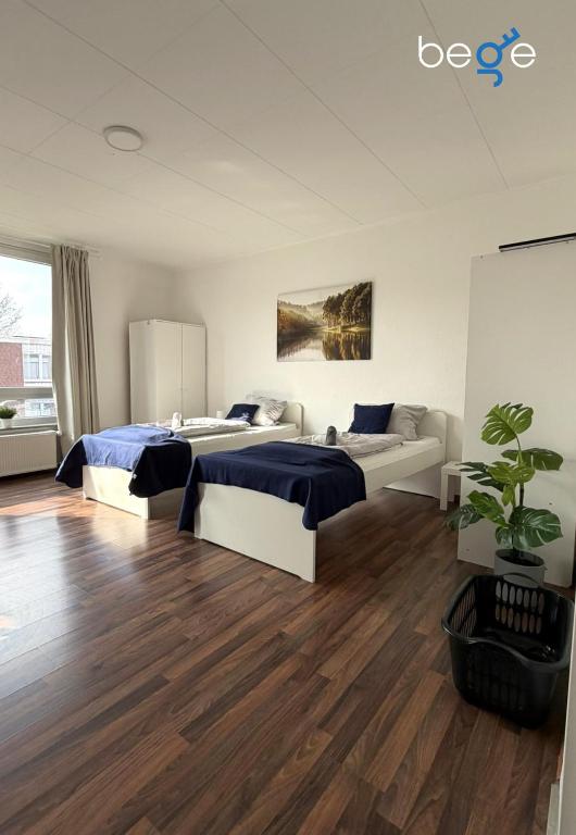 a bedroom with two beds and a couch at BEGE APARTMENTS WorkPoint in Dorsten
