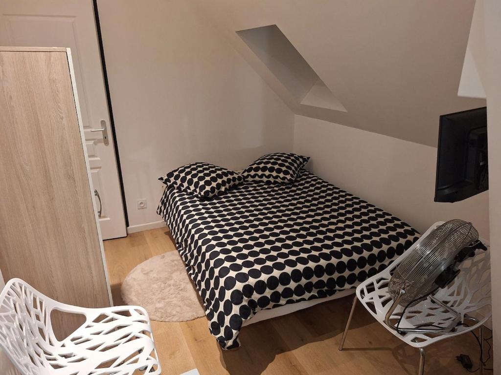 a bedroom with a black and white bed and a chair at Studio confort in Saint-Omer