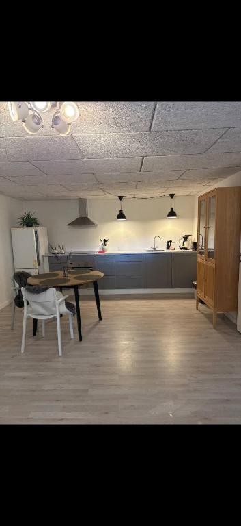 a living room with a table and a kitchen at Hørballegård in Skanderborg