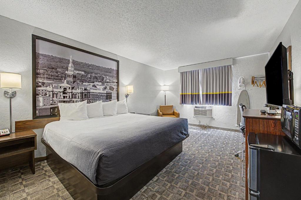 a hotel room with a bed and a flat screen tv at Super 8 by Wyndham Dubuque in Dubuque