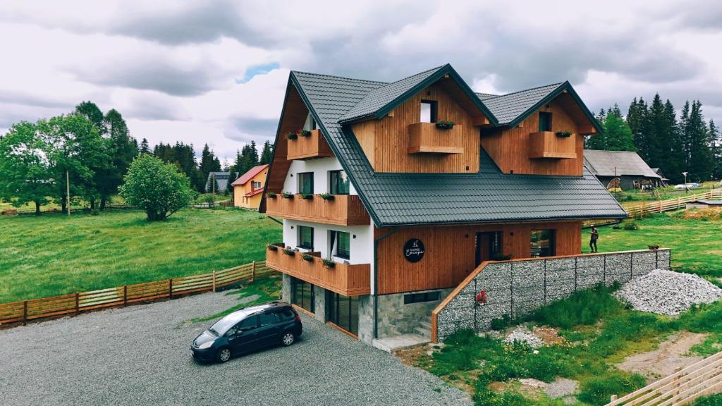 a house with a car parked in front of it at Marisel Escape Chalet in Mărişel