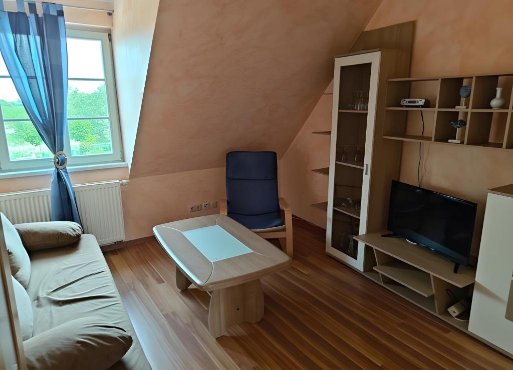 a living room with a couch and a tv at Fewo Backboard in Röbel