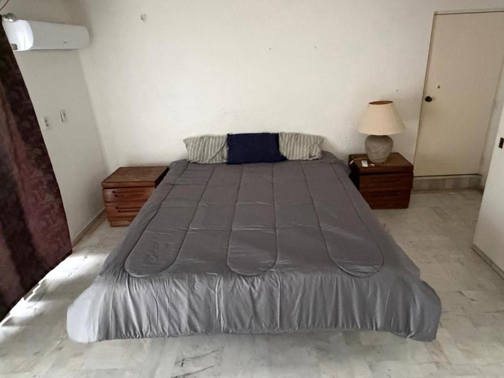 a large bed in a room with a bedspread at Casa Arabesca in Acapulco