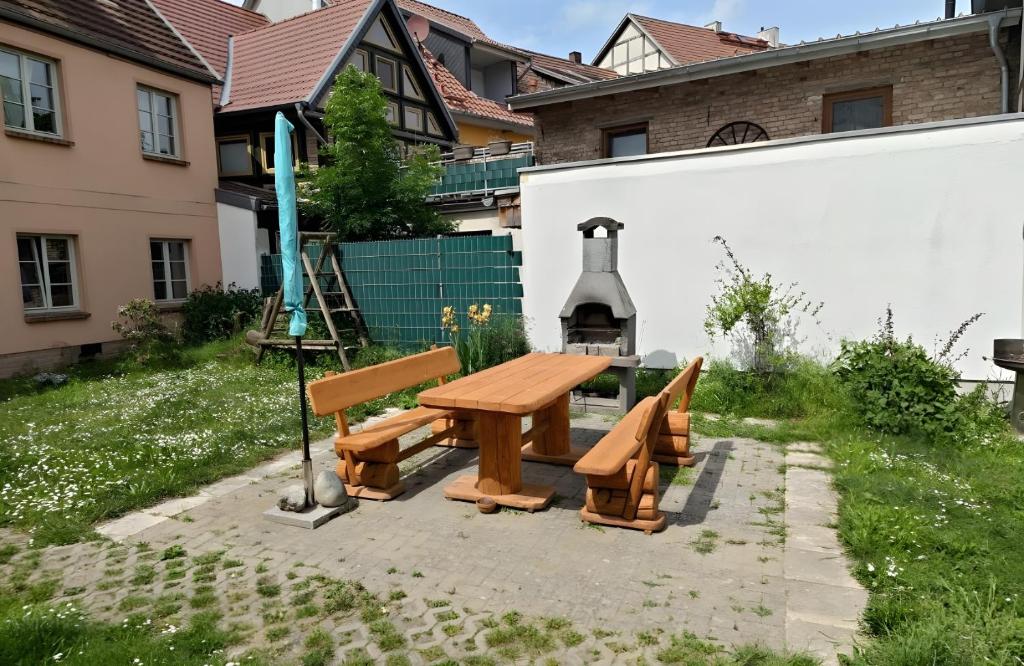 a wooden picnic table and benches in a yard at Fewo Steuerboard in Röbel