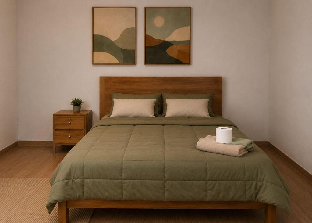a bedroom with a bed with two paintings on the wall at MyAbancayHome in Abancay