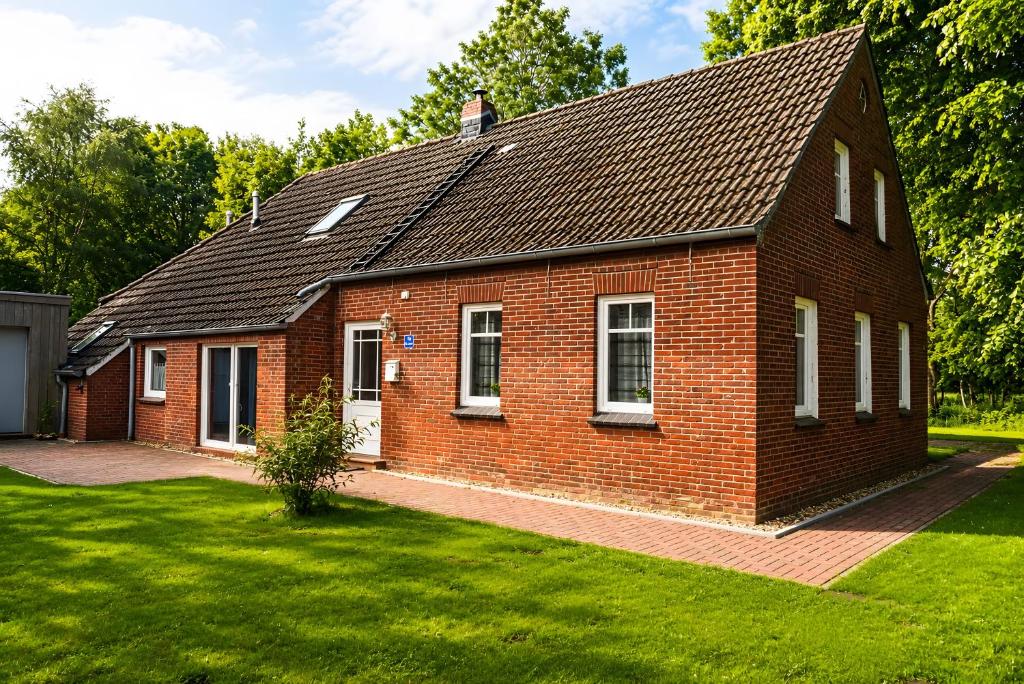 a red brick house with a green yard at Haus Königsfeld in Hage