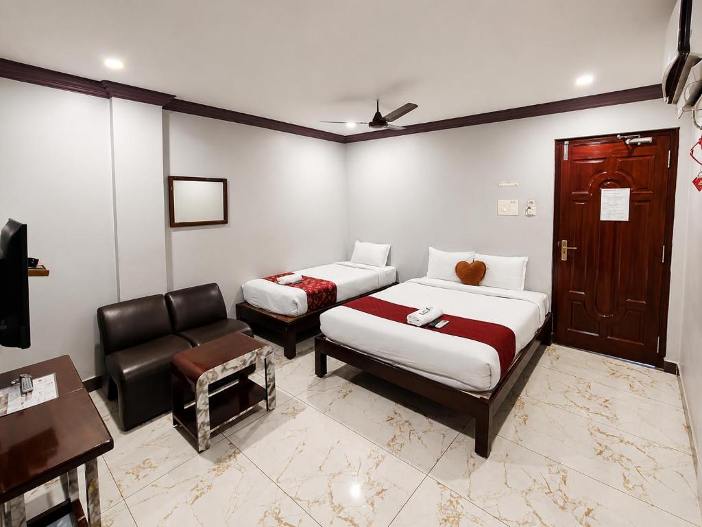 a hotel room with two beds and a chair at Serenity Sunrise Beach Resort in Pondicherry