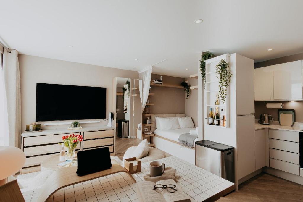 a small living room with a bed and a kitchen at Saturn Studio by Navie Stays in Poole