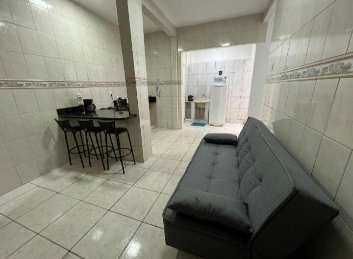 a living room with a couch and a kitchen at Executivo Central 102 in Ipatinga