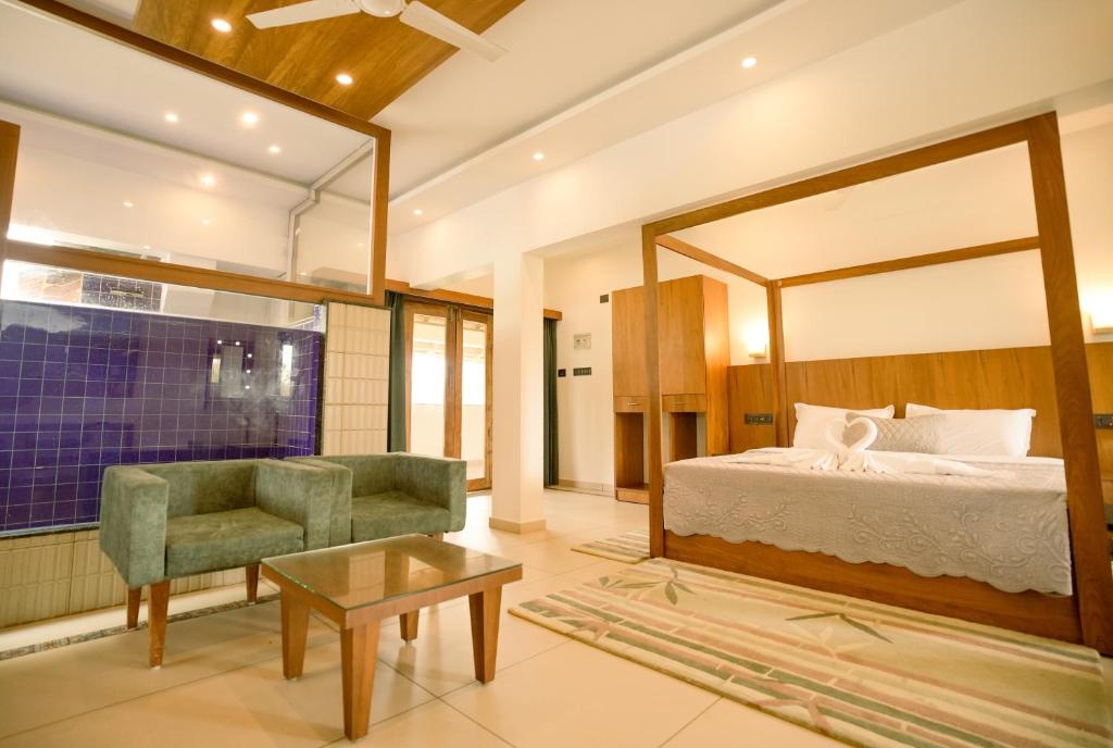 a bedroom with a bed and a chair and a table at 36 Palms- Sun and Sand in Cochin
